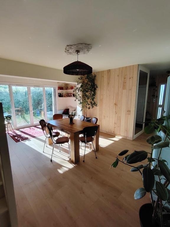 a dining room with a wooden table and chairs at Maison La Séréna in Arès