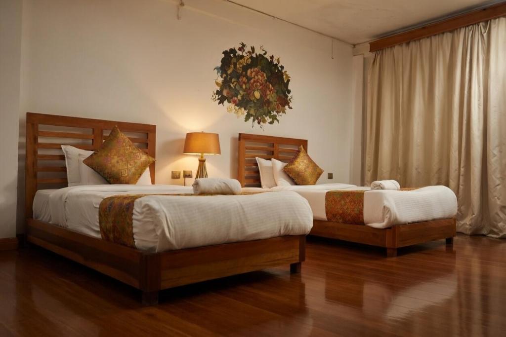 two beds in a hotel room with at Kingaling Hotel in Punākha