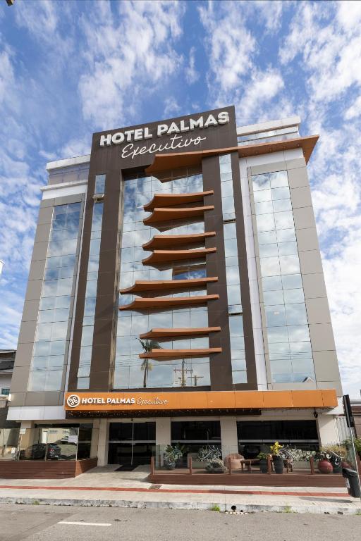 a hotel building with a sign that reads hotel palms absorption at Hotel Palmas Executivo in Balneário Camboriú