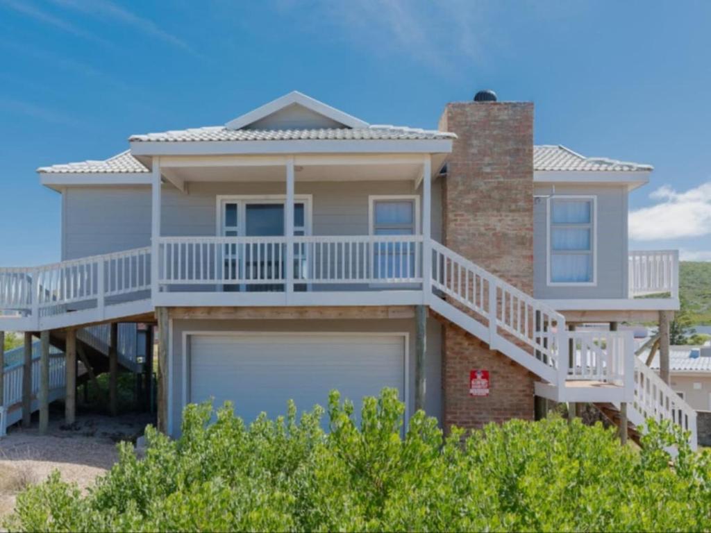 a large house with a balcony and a garage at Poolstreet 18 in Agulhas