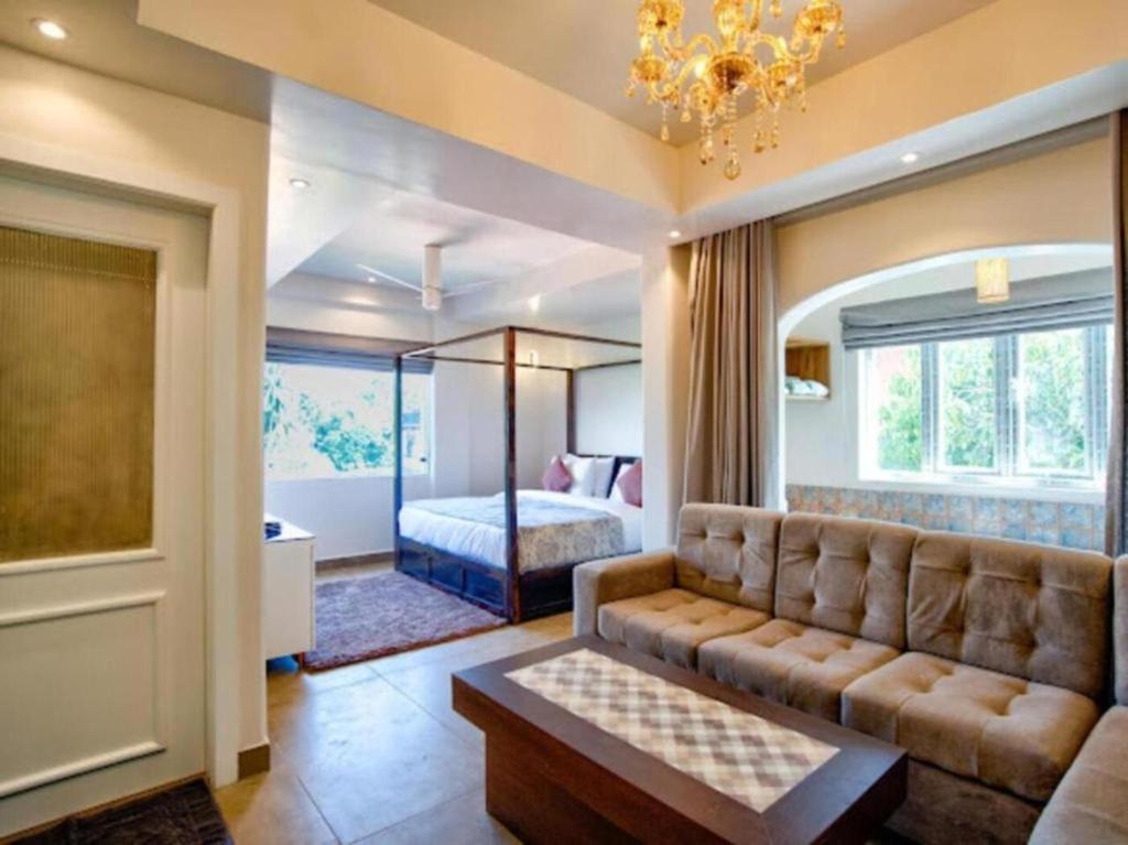 a living room with a couch and a bed at Hotel Pajaros Blu in Calangute