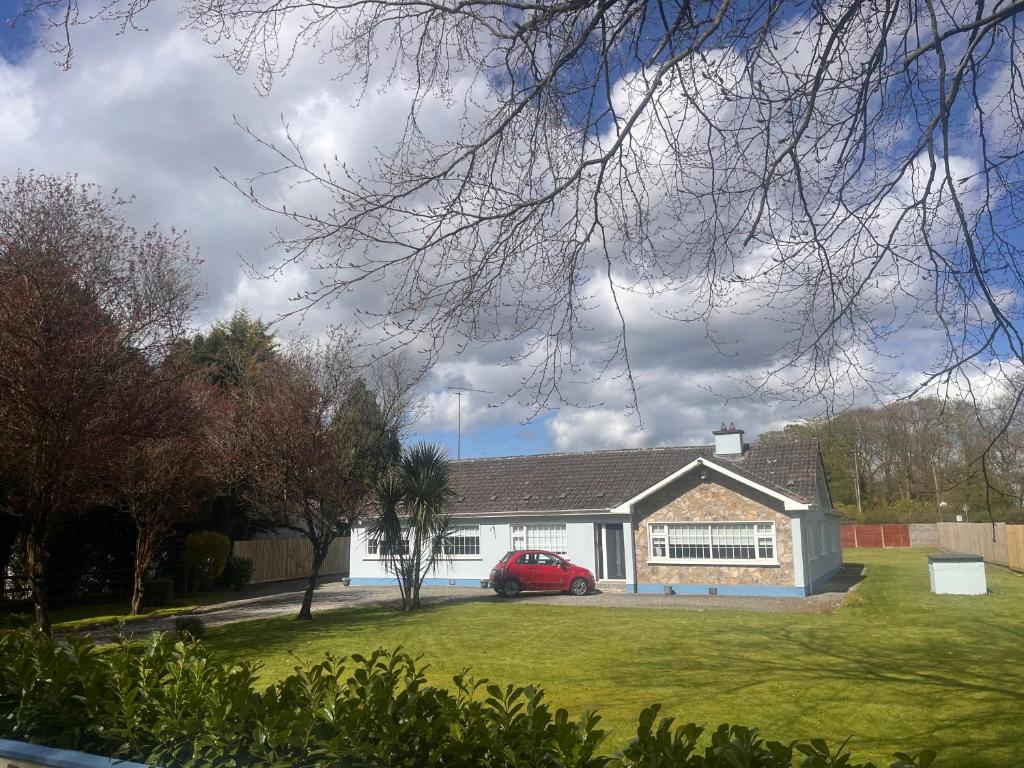 a house with a red car parked in front of it at Countryside Family Home in Balrath