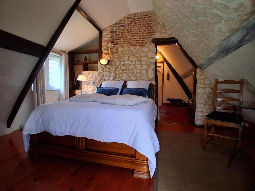 a bedroom with a large bed in a attic at Chambre d' hôtes Etigue - Etretat in Les Loges