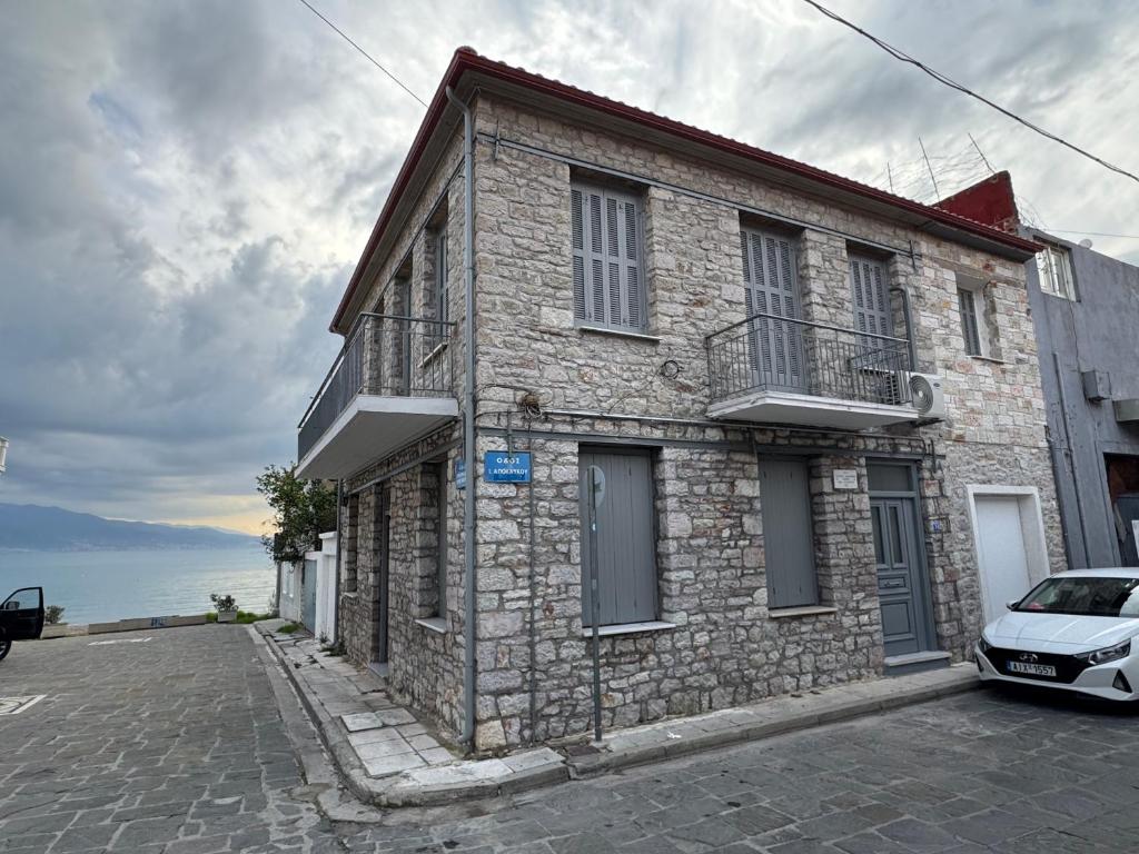 a stone house with a car parked in front of it at Sea & Stone House in Nafpaktos