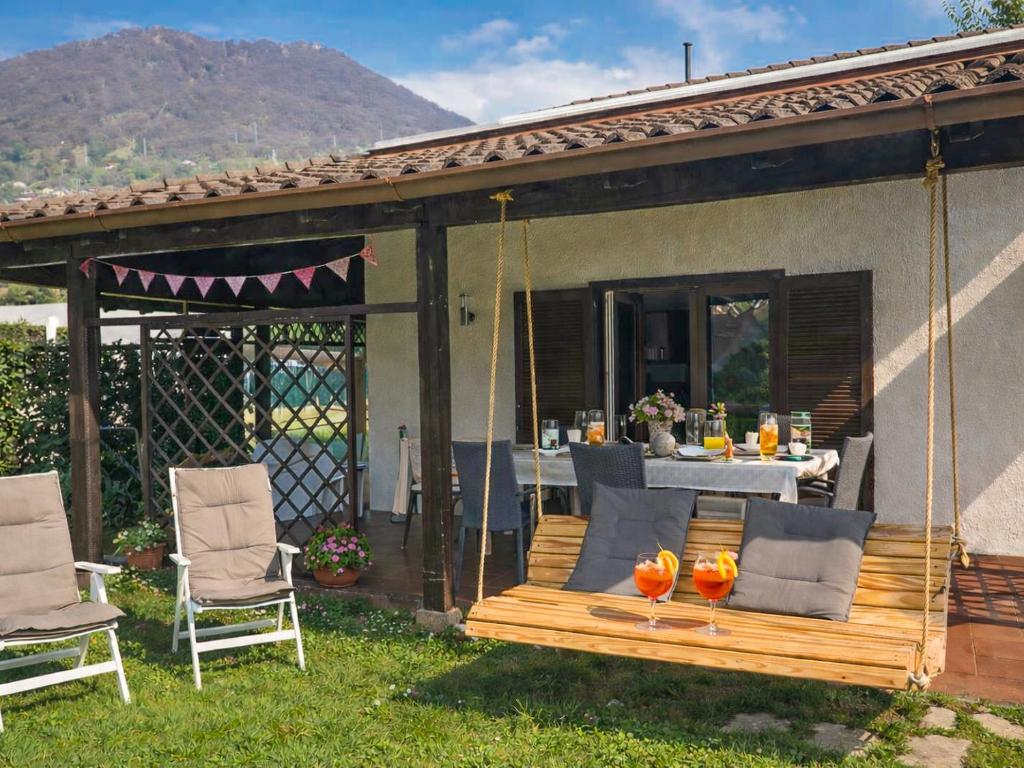 a porch with a swing and two chairs and a table at Lago Lodge Claudia in Domaso