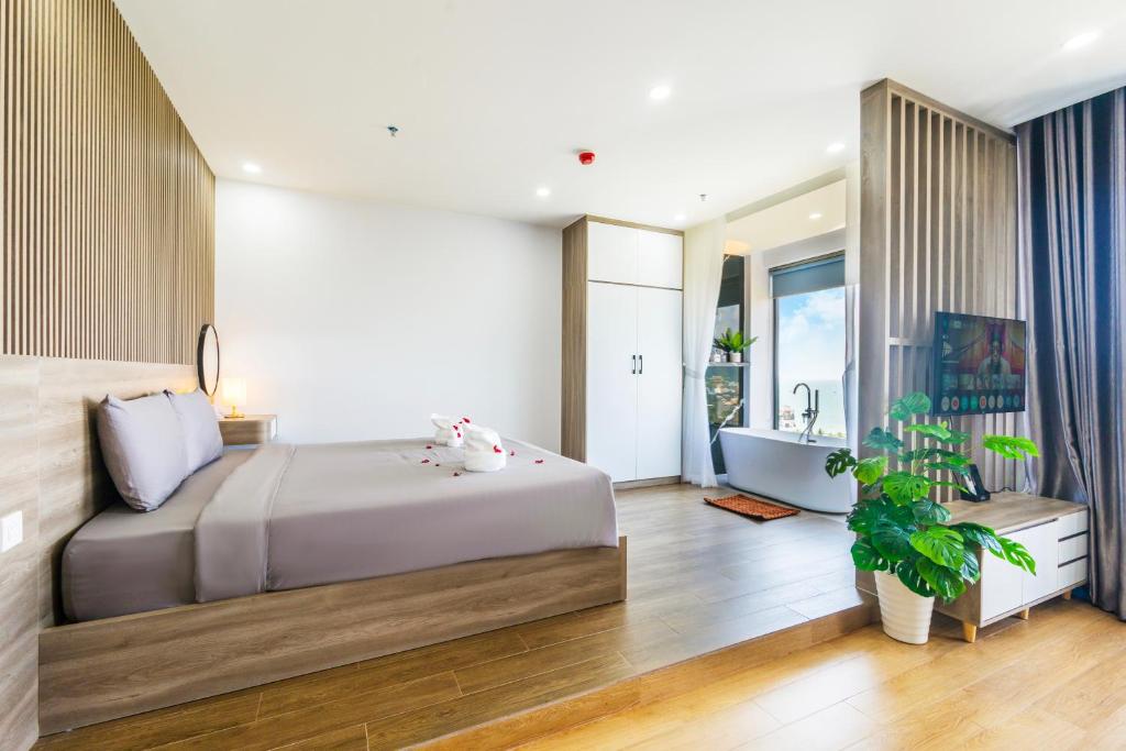 a bedroom with a bed and a tub and a sink at La Cheminee Boutique Apartment in Phú Quốc