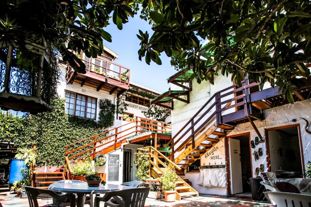 a building with stairs and tables and chairs at Zoete Inval Travelers Lodge-Backpacker Loft in Hermanus