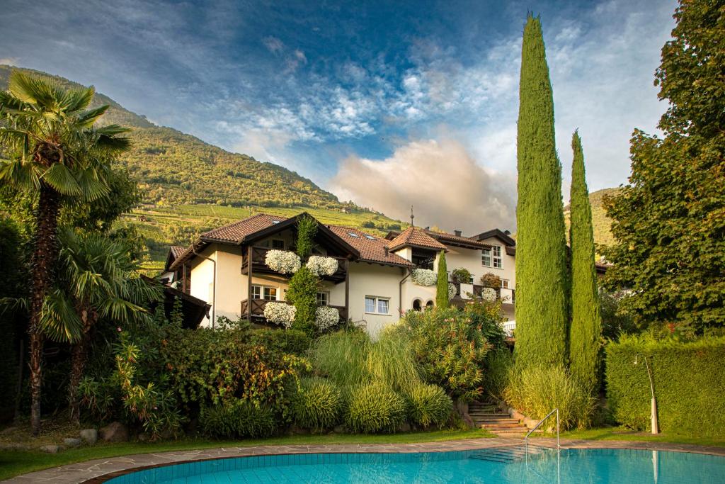 a house with a swimming pool in a garden at Hotel Magdalener Hof in Bolzano