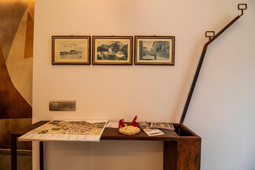 a table with a map and pictures on a wall at Casa Peppina in Gubbio