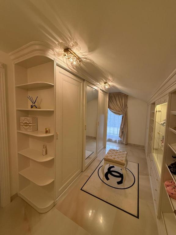 a dressing room with white walls and white shelves at Lily Rose villa in Karlovy Vary