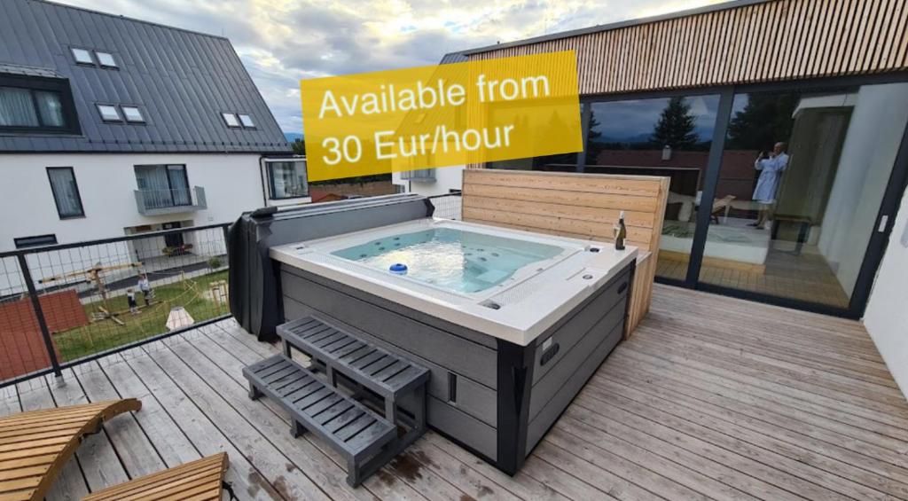 a hot tub sitting on a deck with a chair at Jane's Resort Studio by Tatralandia & Lake in Liptovský Mikuláš