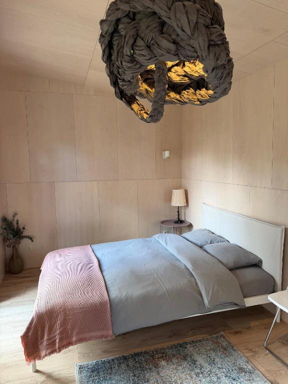 a bedroom with a large bed and a chandelier at D a c h a in Ventspils