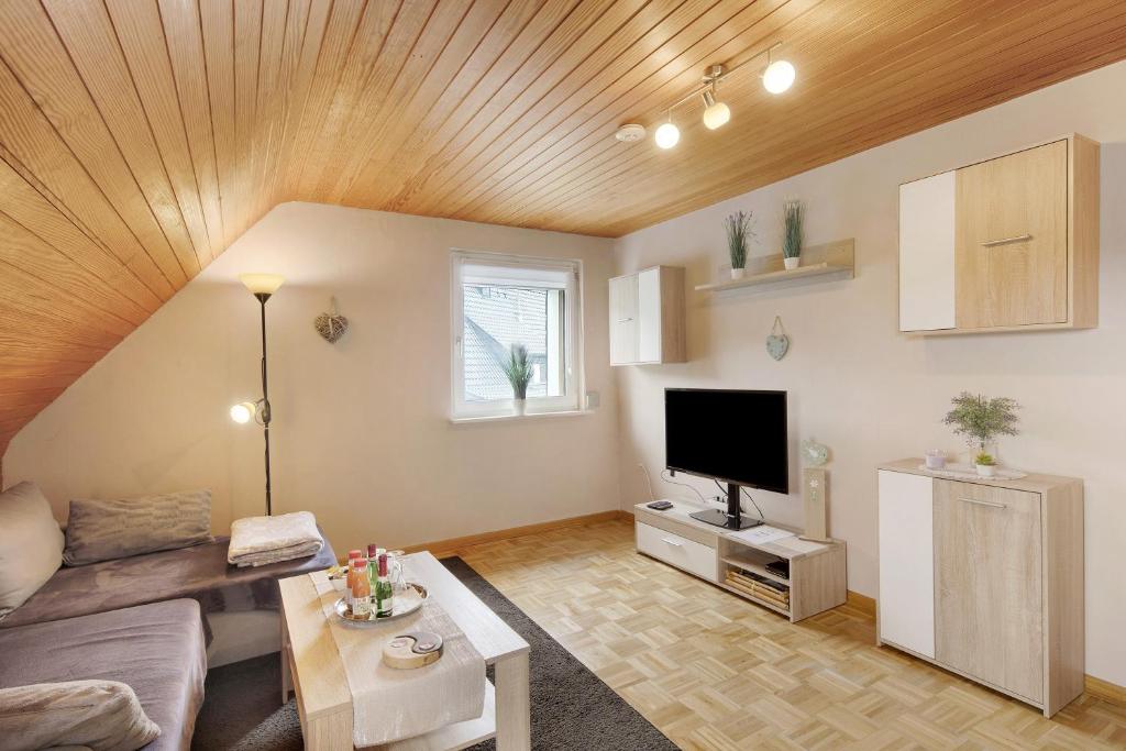 a living room with a couch and a flat screen tv at Tati's Ferienwohnung Siegerland in Hilchenbach
