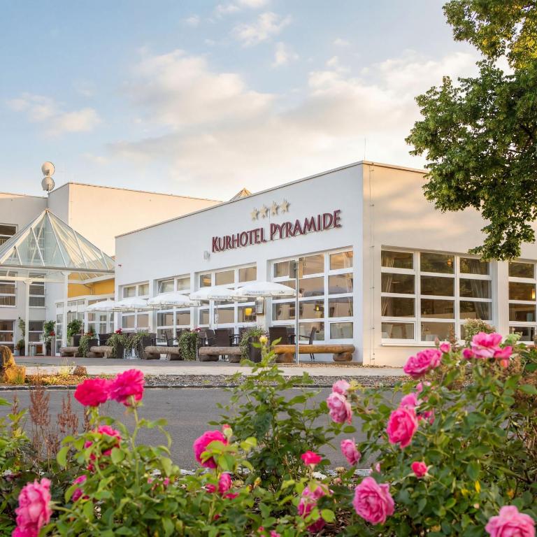 a building with pink flowers in front of it at Kurhotel Pyramide Sibyllenbad in Neualbenreuth