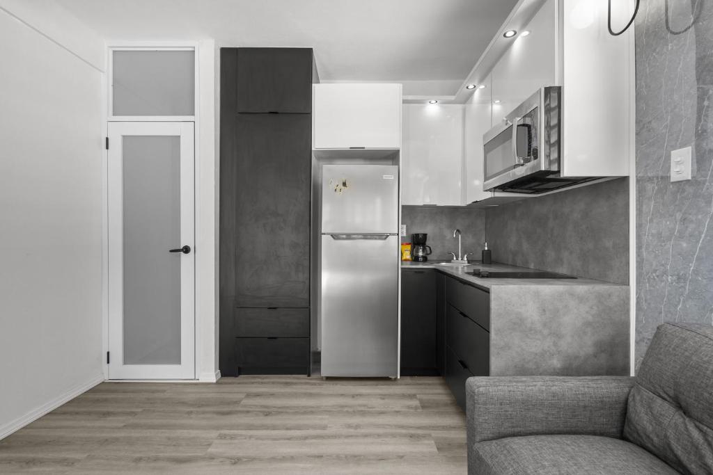 a small kitchen with a refrigerator and a couch at La Balandra Luxury Stays in Dorado