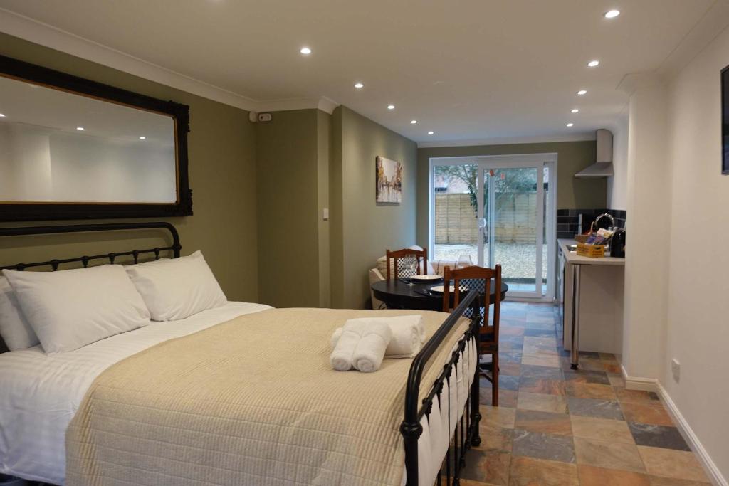 a bedroom with a large bed and a dining room at Modern Bicester Studio Self-Contained with Parking in Bicester
