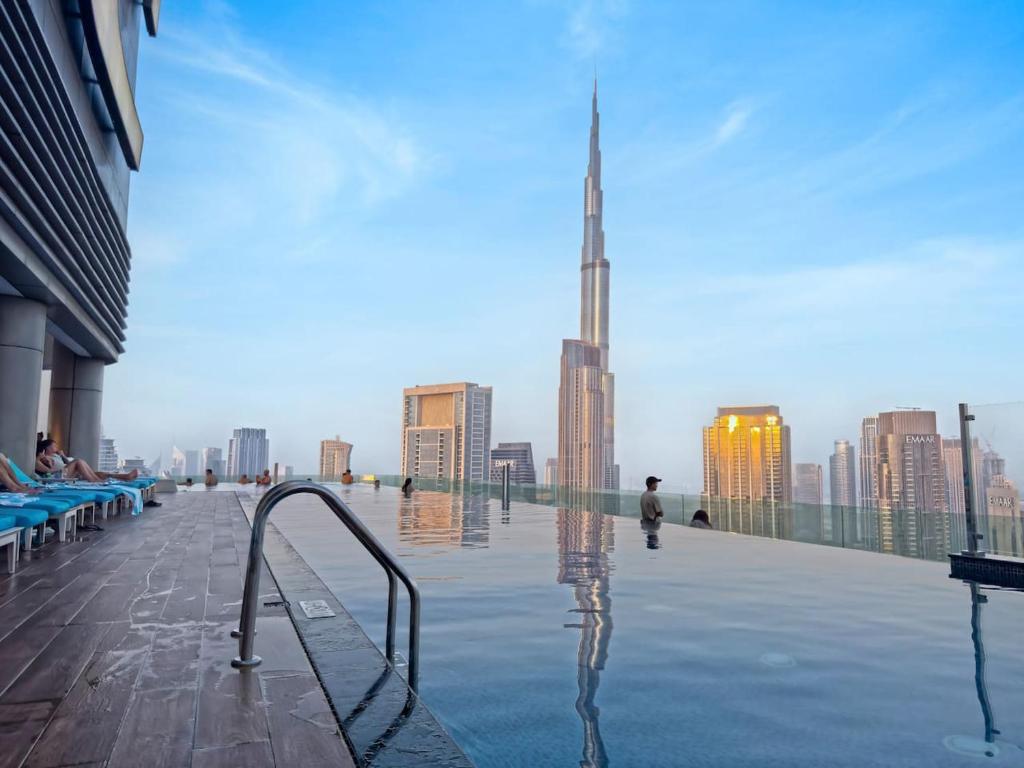 a pool on the roof of a building with a view of a city at 3br - PoolAccess - 7 MinstoDubai Mall - 2 KingBeds in Dubai