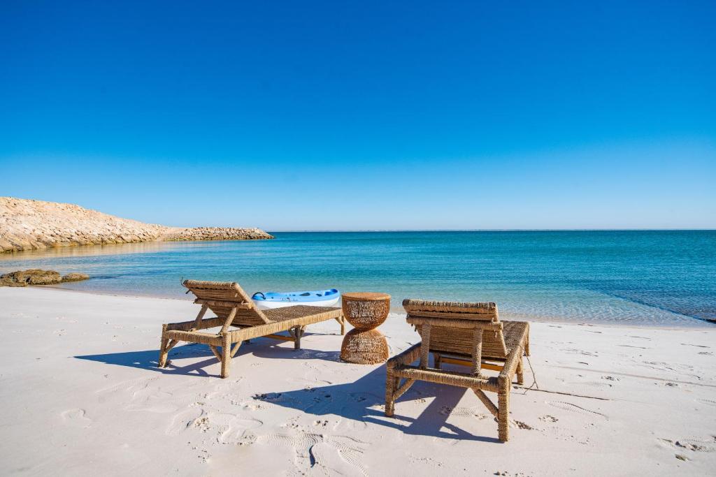 two chairs and a picnic table on the beach at Loft Beachfront Bungalow with Private Beach in Dakhla