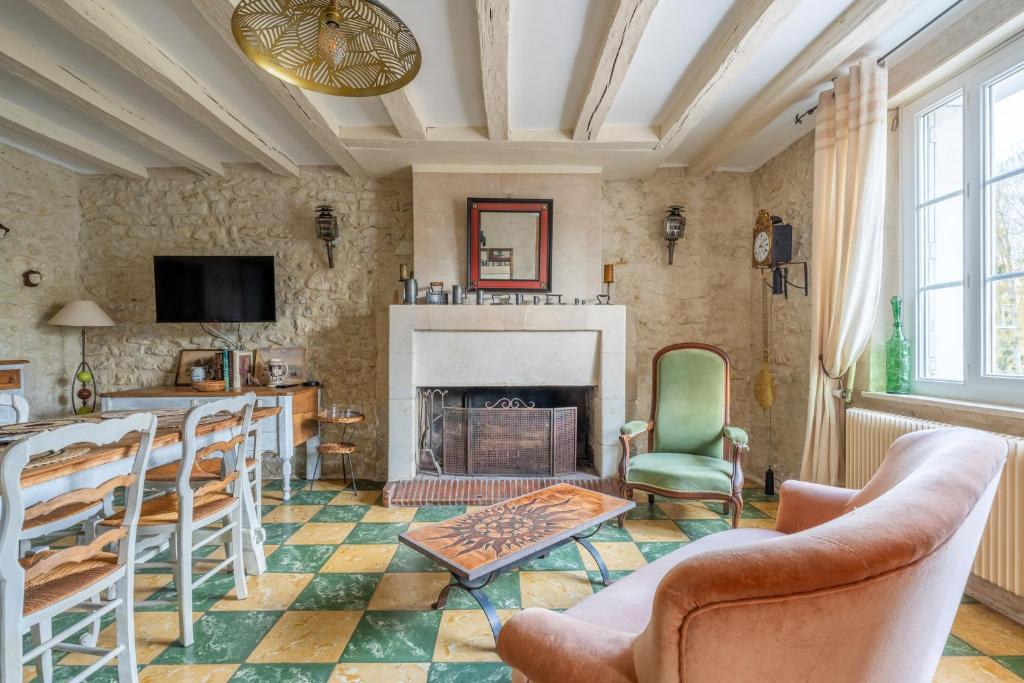 a living room with a fireplace and a table and chairs at Maison semi-troglo - Proche Chenonceaux - Amboise - La Caburoche de Charlemagne in Civray-de-Touraine