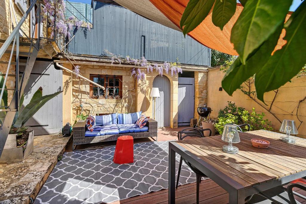an outdoor patio with a couch and a table at L'Annexe Gîte Premium in Groléjac