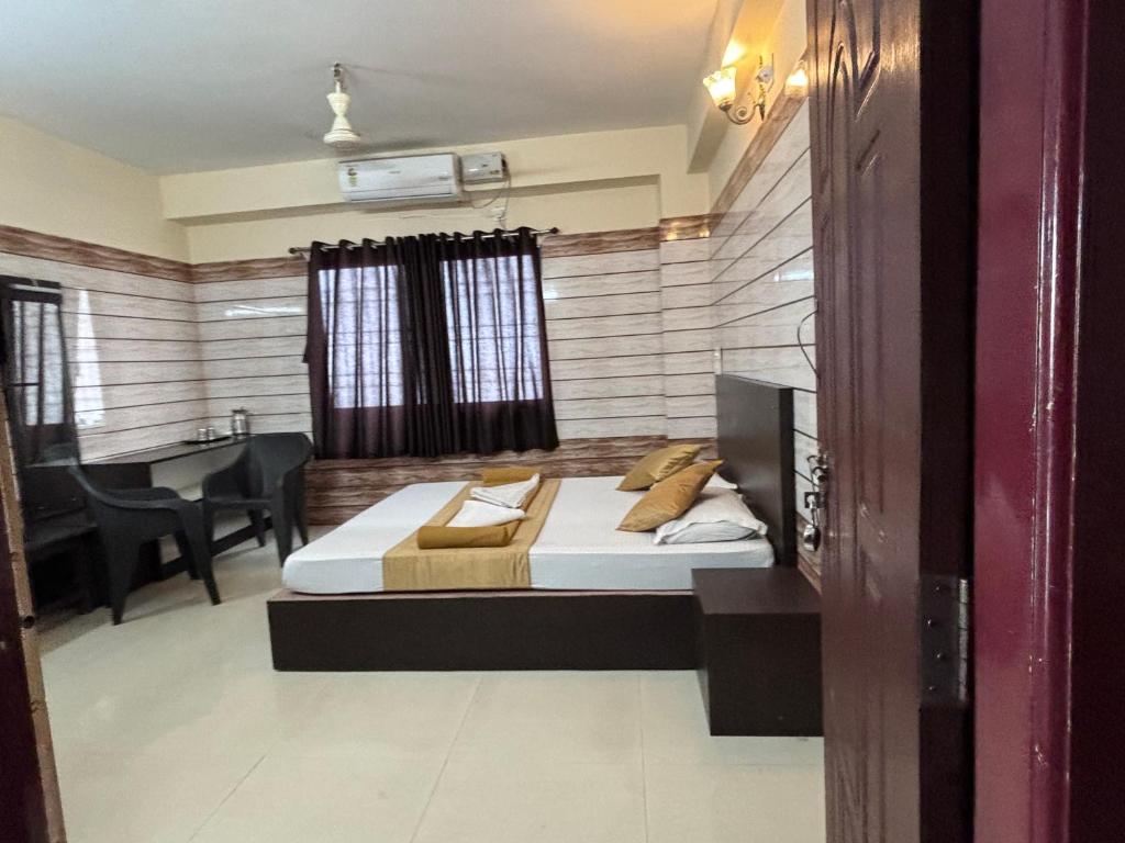 a bedroom with a bed and a dining room at Hotel Yamunna Boarding and Lodgeing in Kollūru