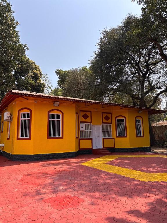 a yellow building with a red brick driveway at Lilly Beach House in Kīhīm