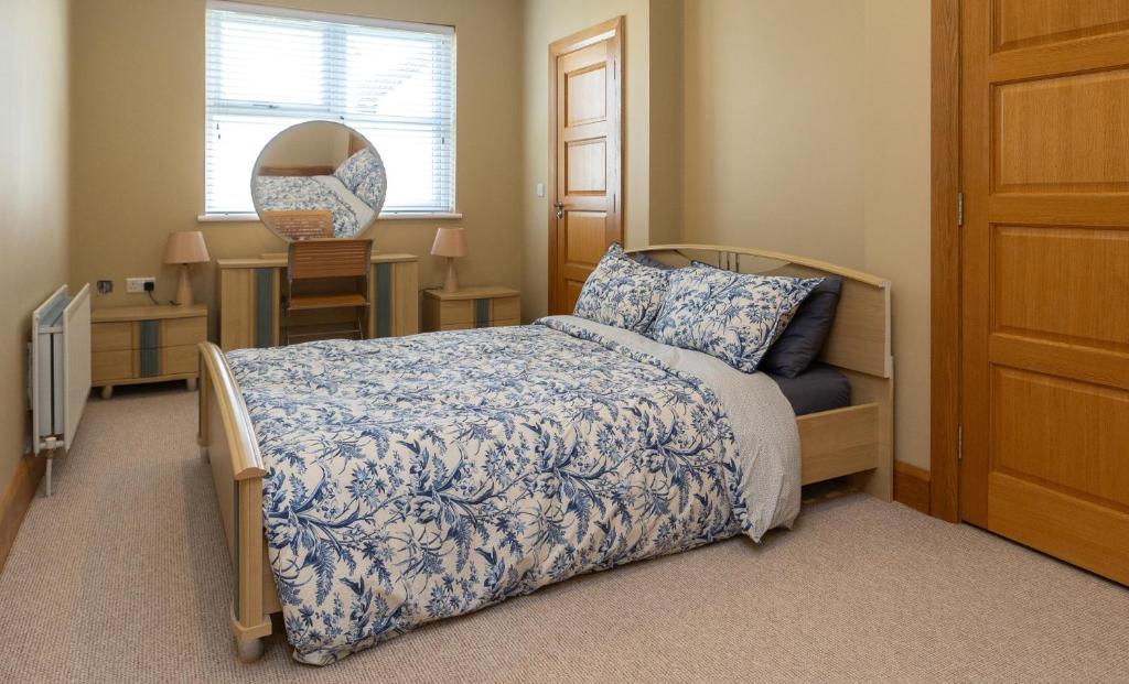 a bedroom with a bed and a desk with a mirror at Copperbeech Farm Guest House in Moira