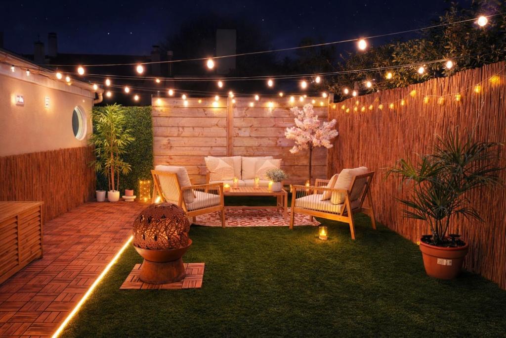 a patio with a table and chairs and lights at L Antre du Désir in Saint-Léonard