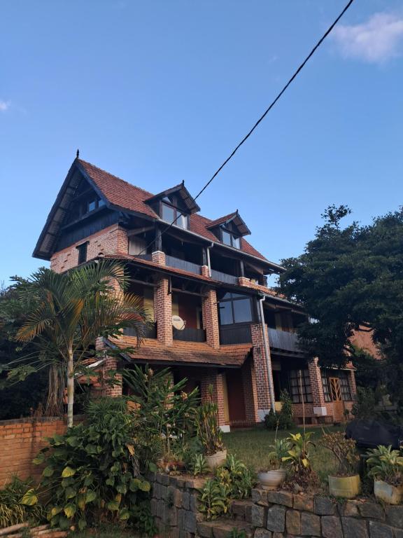 a building with a palm tree in front of it at Hotel Anjara in Ambositra
