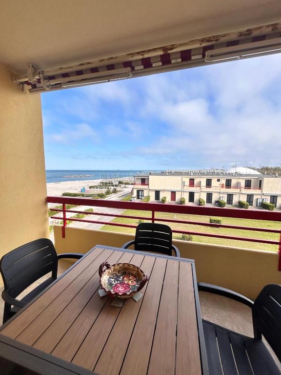a table on a balcony with a view of the beach at La casa di Giorè - Fronte Mare Gabbiani Ombrellone e 2 lettini inclusi in Fano