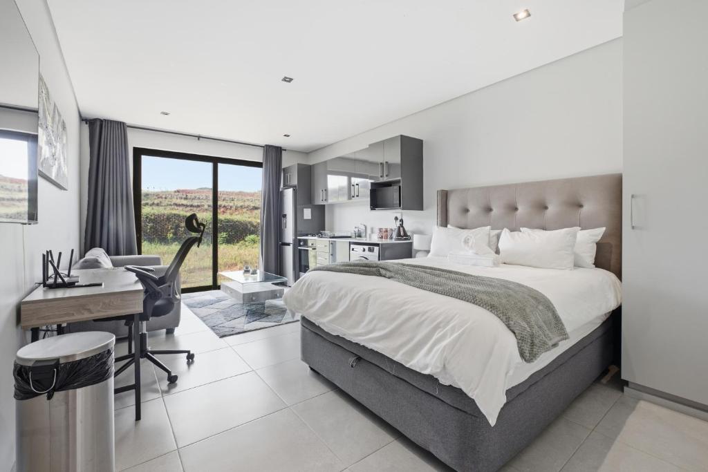 a bedroom with a large bed and a desk and a desk at Vista Zimbali in Ballito