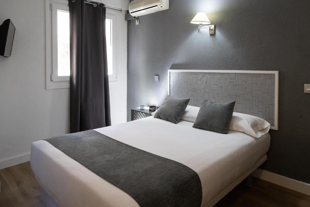a bedroom with a large bed and a window at Alda Centro Palencia in Palencia