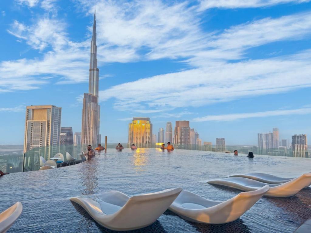 a infinity pool with chairs on the roof of a building at Near Dubai Mall PoolAccess SunSetView KingBed in Dubai
