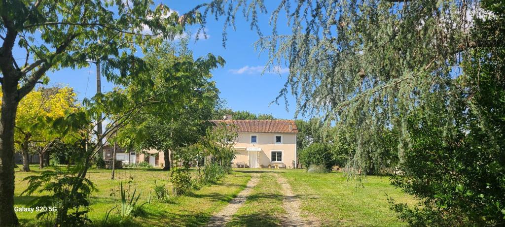 a dirt road in front of a house with trees at Le Chai d'Auguste in Pauilhac