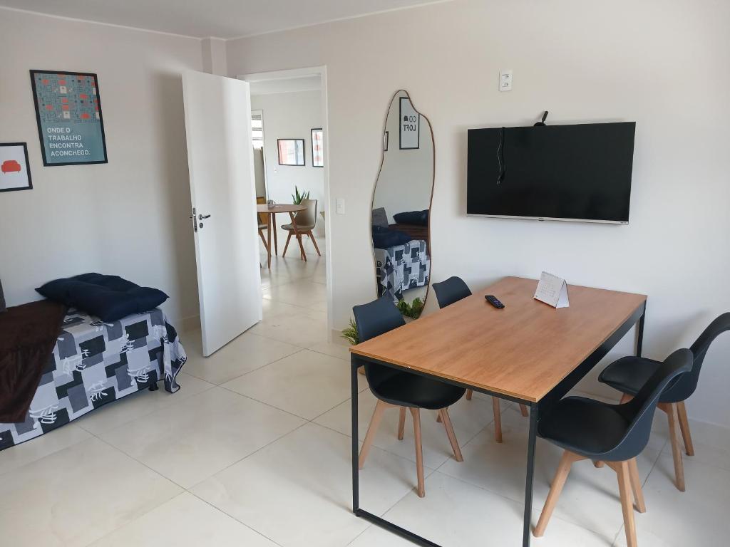 a dining room with a table and chairs and a mirror at COLOFT - Quarto 4 Hospedagem rápida ou Sala de reunião in Anápolis