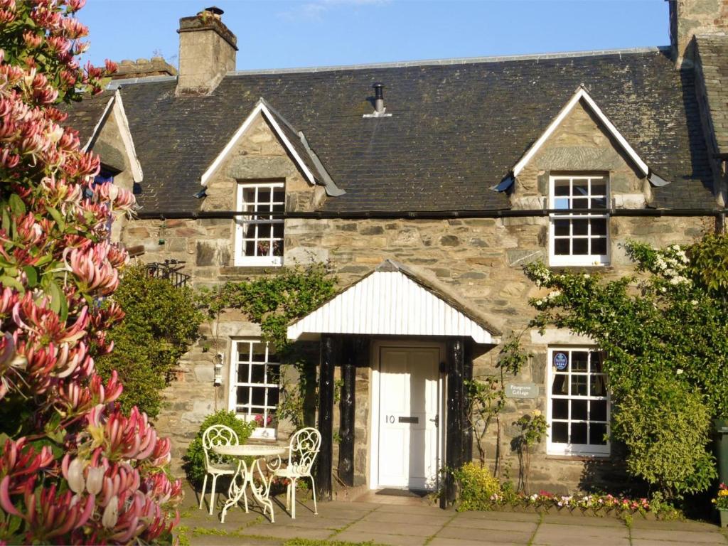 a stone house with a table and chairs in front of it at 2 Bed in Birnam Dunkeld oc-ca266 in Birnam