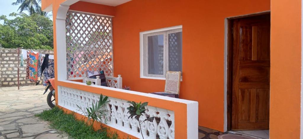 an orange house with a window and a door at Orange apartment 1 in Watamu