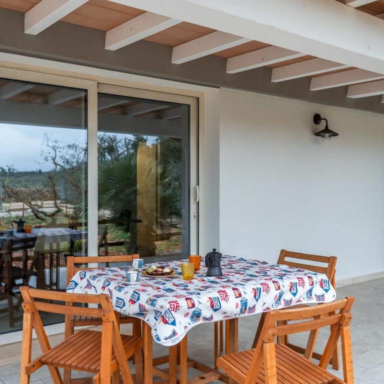a table with two chairs and a tablecloth on a patio at Domo Appeddu in Orosei