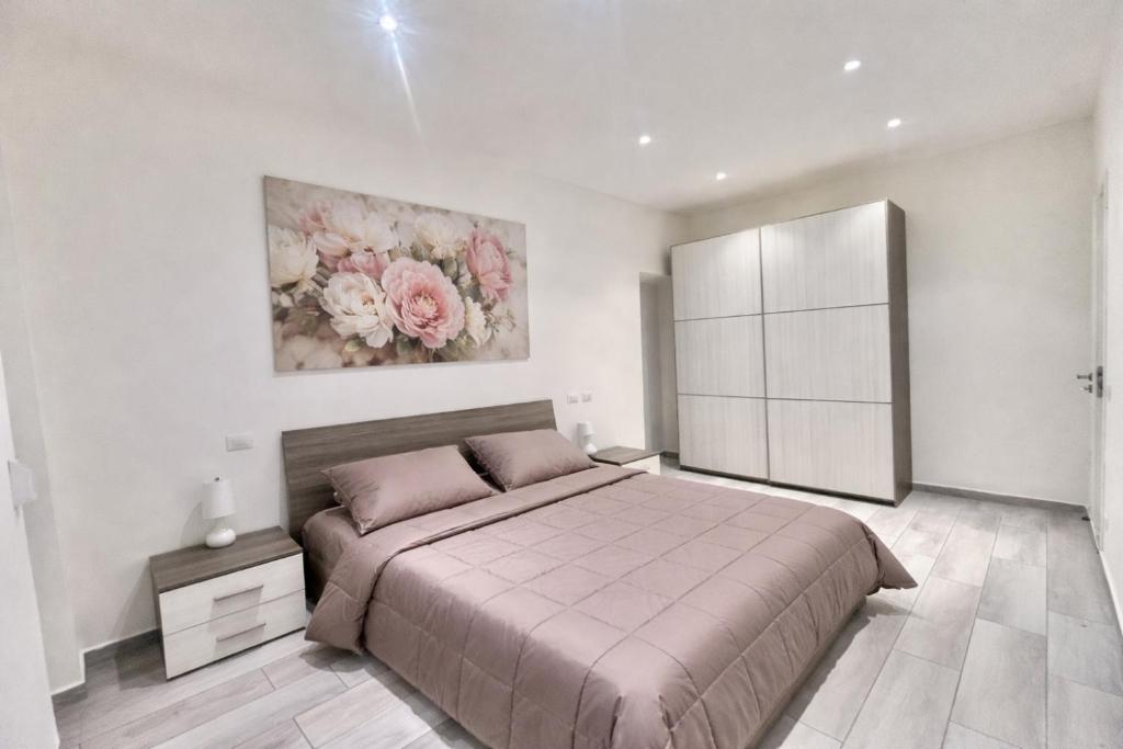 a bedroom with a bed and a painting on the wall at Alloggio Nala 6 in Biella