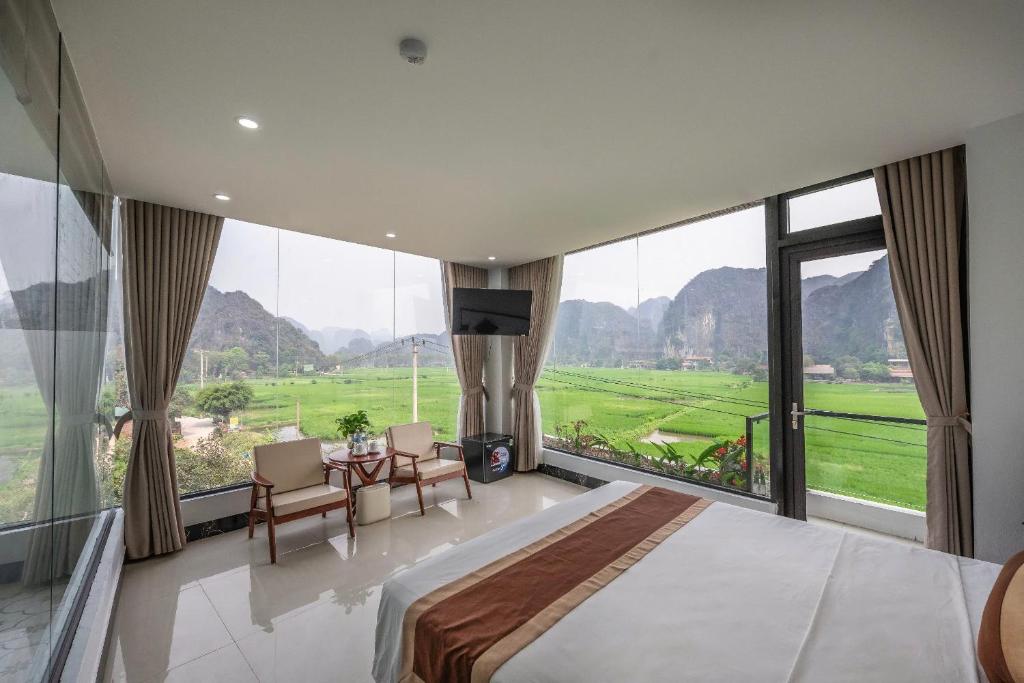 a bedroom with a large bed and a table with chairs at Tam Coc Sunshine Villa in Vũ Lâm
