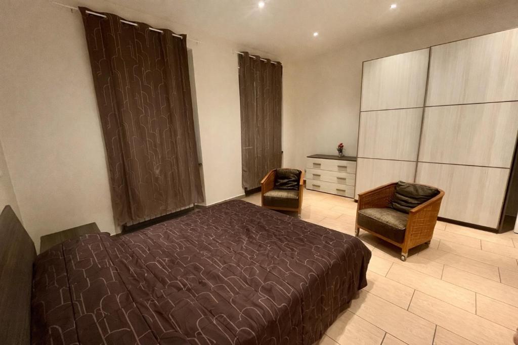 a bedroom with a bed and a chair and a dresser at Alloggio Nina 2 in Biella