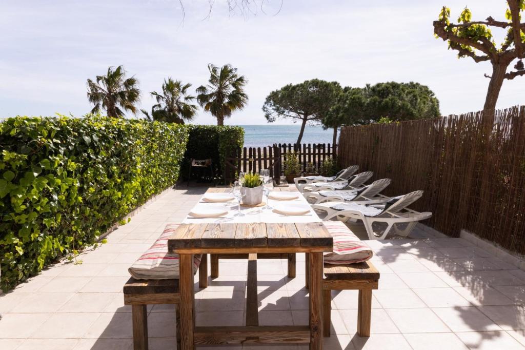 a table and chairs on a patio with the ocean at Baconer - Casa en l'Ampolla con jardín privado y acceso directo al mar - Deltavacaciones in L'Ampolla