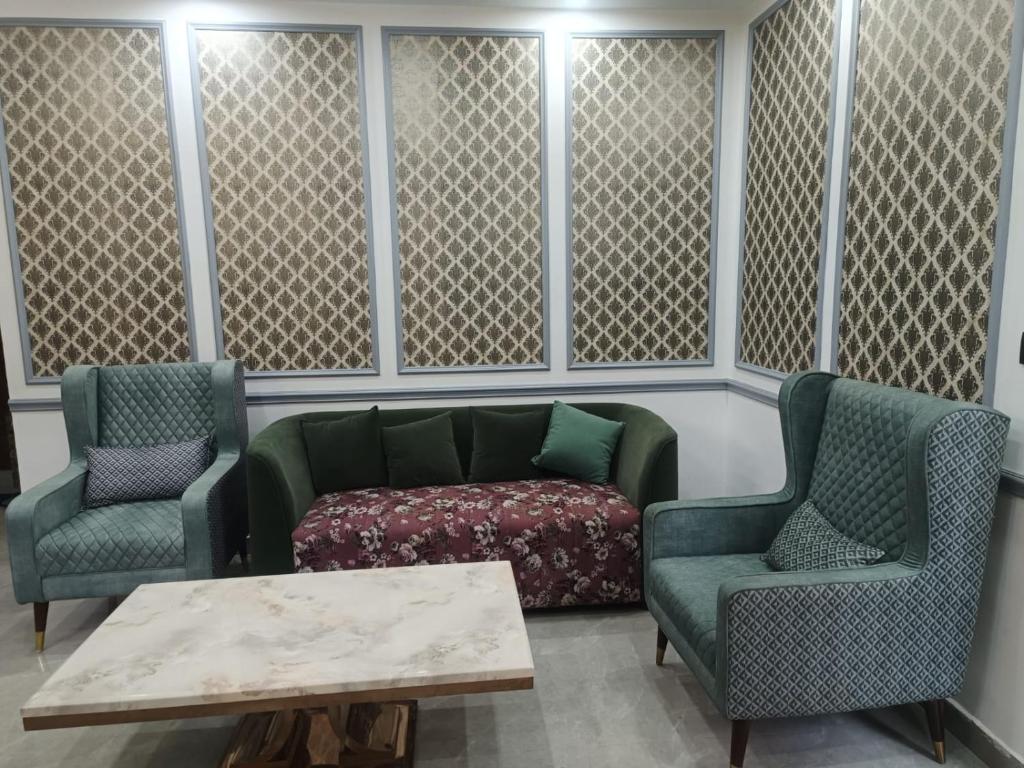 a waiting room with a couch and two chairs and a table at THE BBN Hotel in Solan
