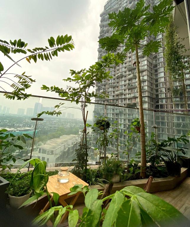 a room with a table and trees and a building at Caracole homestay - 2BR with cozy balcony garden in Kim Quan