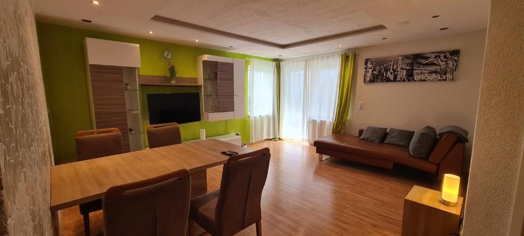 a living room with a dining table and a couch at WellandHome- Deluxe Apartment Schechingen in Schechingen