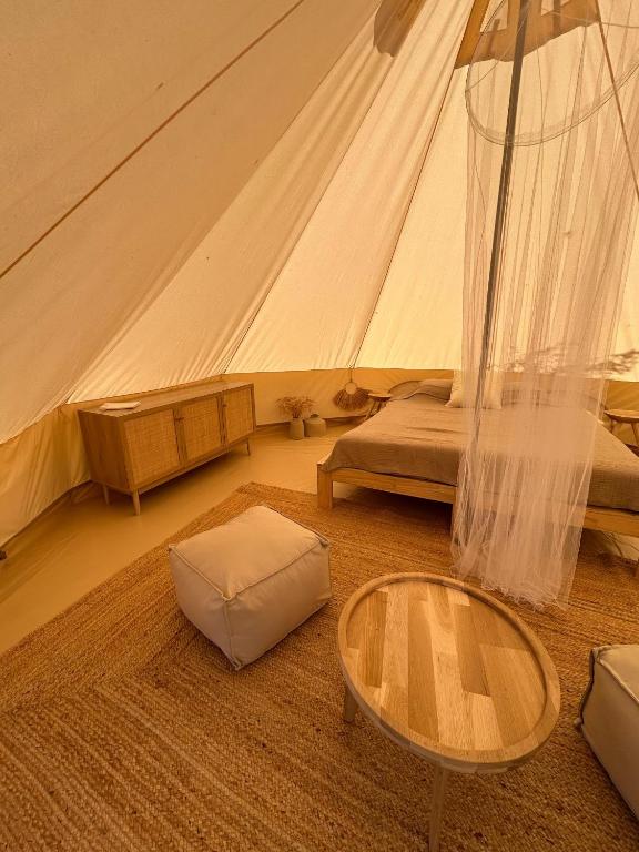 a room with a tent with a table and a bed at Amurg Glamping&Pool in Vadu