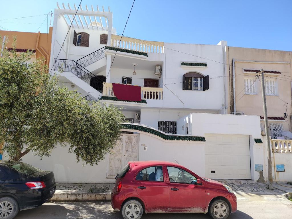 a red car parked in front of a building at Studio ANDALOUS in Mahdia
