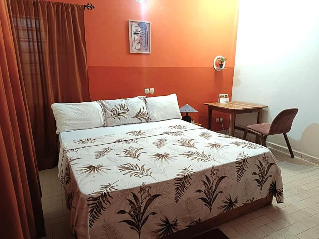 a bedroom with a bed and a table and a table sidx sidx sidx at Cloud9 Lomé in Lomé