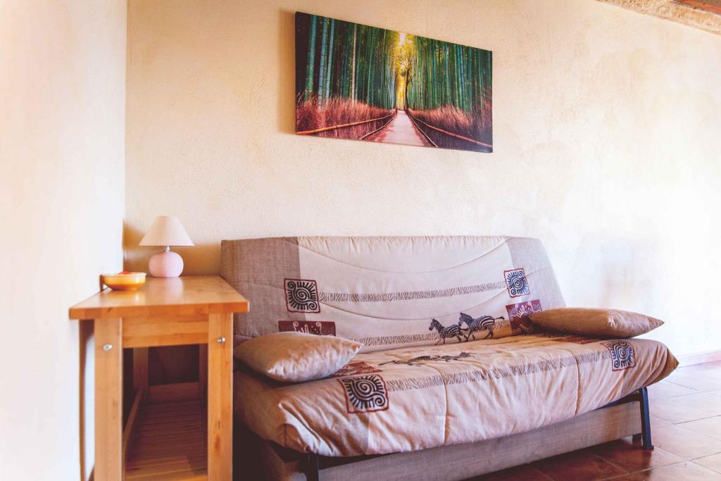 a couch in a room with a table and a painting at La Vall de Silvestre in Mas de Barberáns