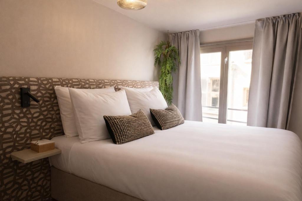 a bedroom with a large bed with pillows and a window at Hotel Central Staytion in Amsterdam